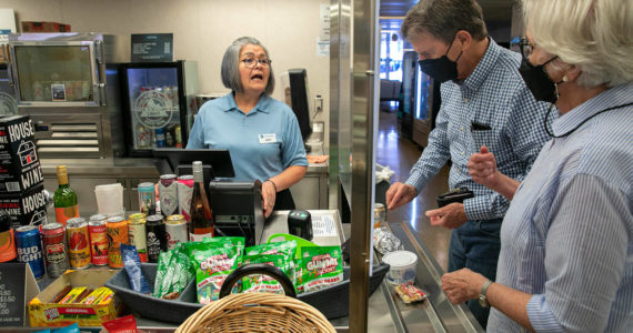 Maria Rios, a galley cashier, helps Frank and Fran Butler, of Washington, D.C., with food purchases aboard the Suquamish ferry between Mukilteo and Clinton. The galley is among several reopened after being closed over two years due to the pandemic. The galley of the Tokitae, the other boat on the Mukilteo-Clinton route, remains closed for now. (Ryan Berry / The Herald)