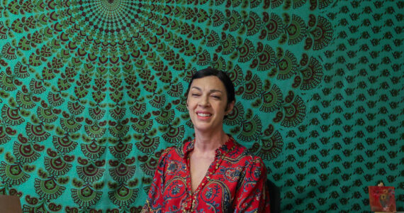 Photo by Caitlyn Anderson
Hypnotherapist Jenna Alexander smiles from behind her desk in her office, July 8.