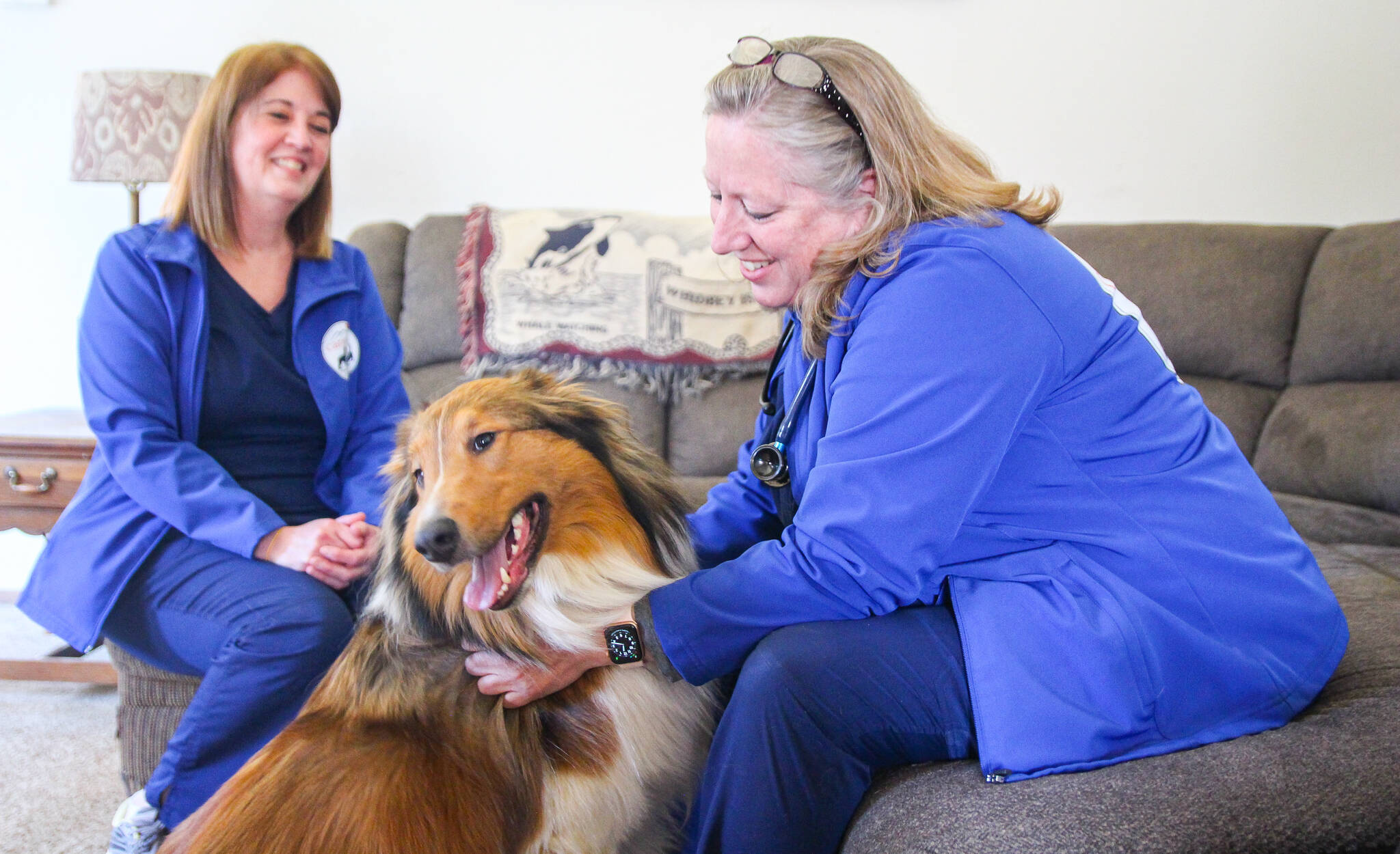 (Photo by Luisa Loi)
At right, Jayne McKelvy and Julie Cathey compliment Rufus for being a good boy during his annual exam. He was also vaccinated for bordetella (a bacterium associated with respiratory disease) and leptospirosis (an infection that can cause vomiting, lethargy, diarrhea and other symptoms). His owner, Kim Connolly, said skipping the drive to the veterinary clinic was a relief.