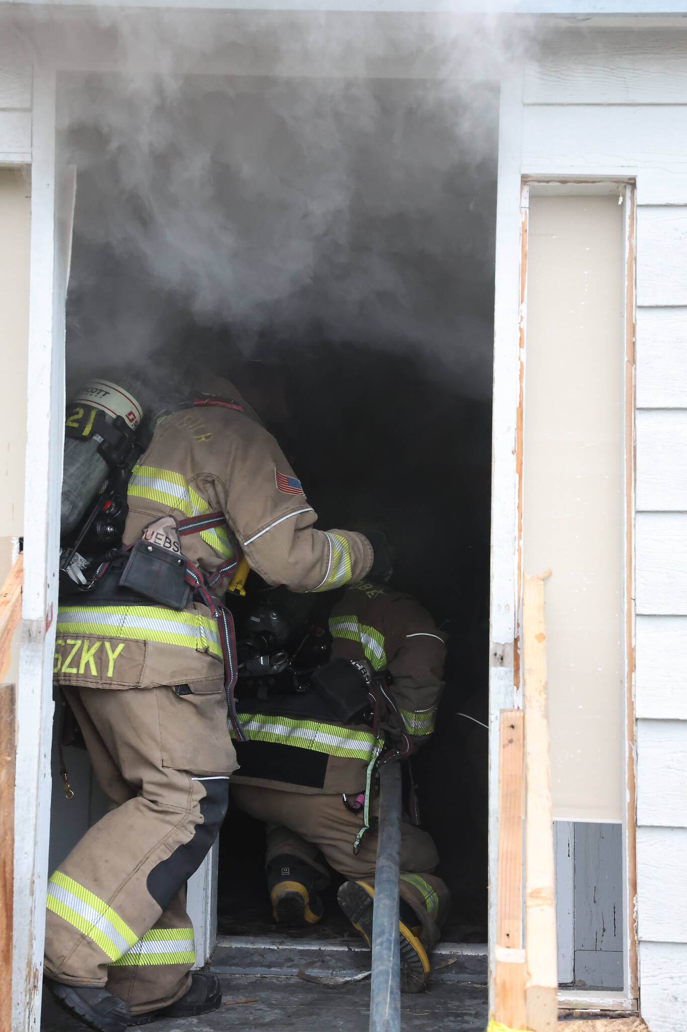 (Photo by John Fisken)
Firefighters venture inside the burning farm house.