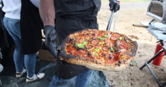 Stoneham shows off a freshly baked Mama's BBQ pizza from Stoneham Pizza