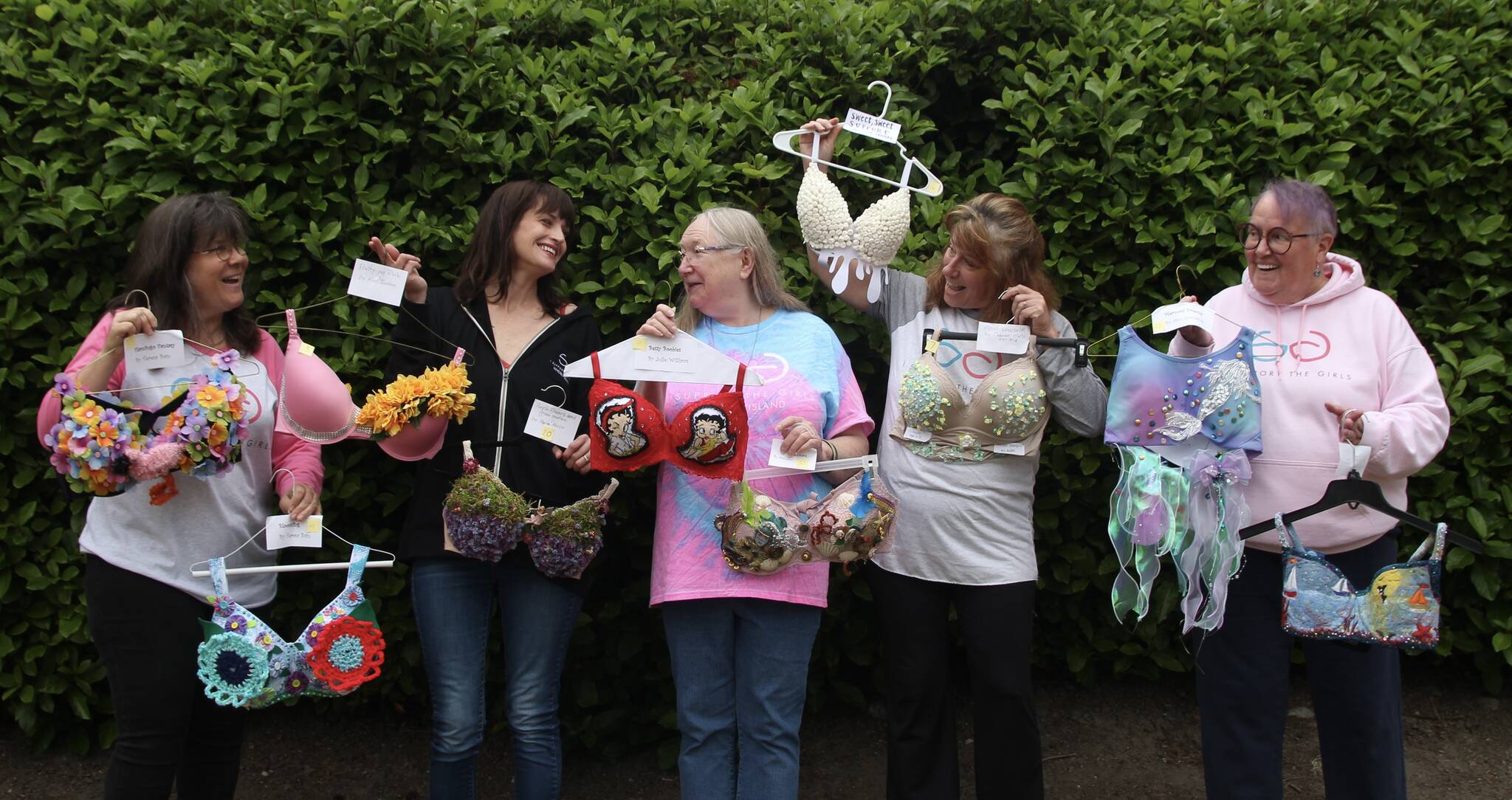 I Support The Girls Whidbey Island volunteers laugh together as they showcase some decorated bras that will be at the auction. From left, Julie Rhodes, Kris Bobadilla, Candy Pearson, Wendy Rue and Kate Mistler (Photo by Marina Blatt)