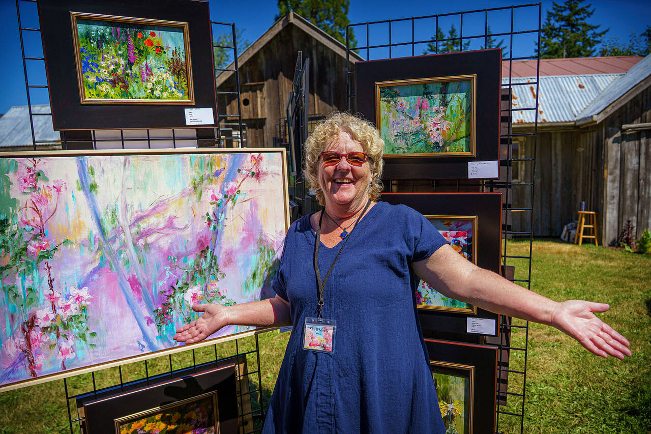 (Photo by David Welton) 
Artist Kim Stokely joyfully displays her art on the garden tour.