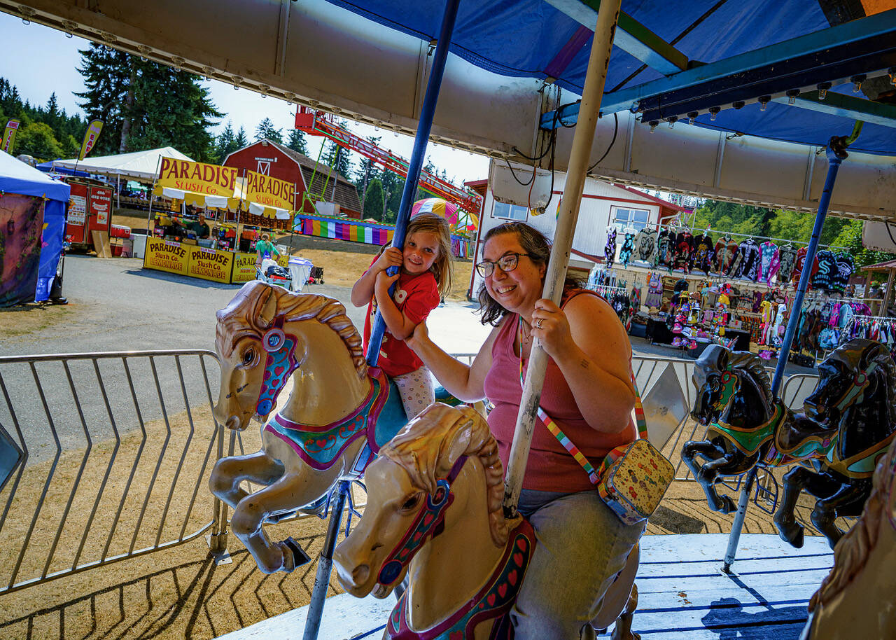 (Photo by David Welton) Aria Mami, 5, and her aunt Natalie Mami, both from Oak Harbor, enjoyed some good old-fashioned fun on the carousel.