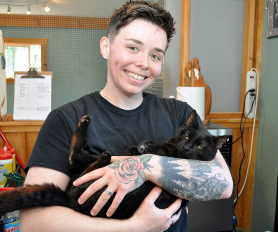 Animal care technician Morgan Kenaley with Shadow at the Freeland Cat Cottage. Photo by Mary Jo Adams.