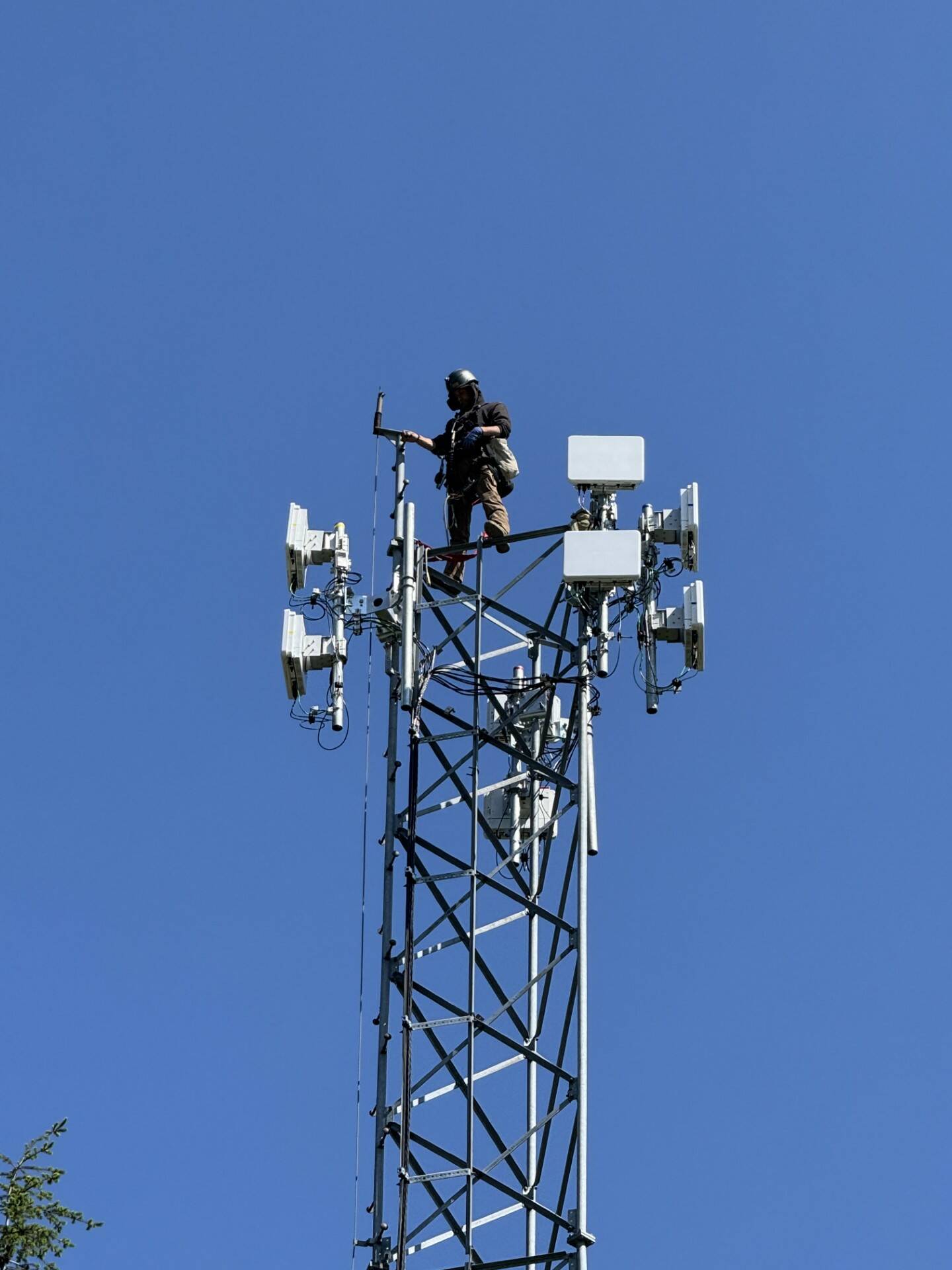 (Photo provided) Astound technician installs a fixed wireless network transmission devices atop an existing headend tower.